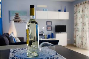 a bottle of wine sitting on a table with a glass at "Mi casita de la playa" in Arrieta