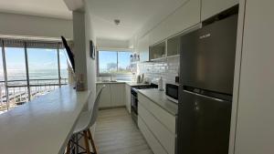a white kitchen with a view of the ocean at Depto Varese - Depto Vista al Mar Zona Varese Para 3 PAX Con Cochera - Hola Sur in Mar del Plata