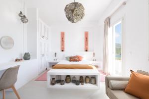 Un dormitorio blanco con una cama y un sofá. en Naousa Villa Kythnos, en Kithnos