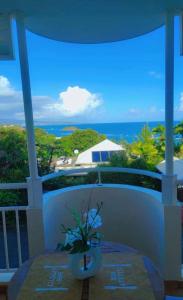 a vase on a table on a balcony with the ocean at Instant Piscine in Desforts