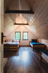 a large room with two beds and two windows at Jedinečné bývanie v blízkosti Banskej Štiavnice in Banský Studenec