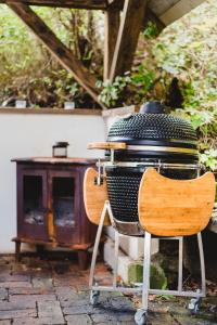 a grill sitting on a chair next to a table at Jedinečné bývanie v blízkosti Banskej Štiavnice in Banský Studenec