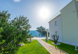 a white house with a garden and trees at Villa Anto in Pridraga