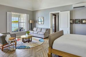 a bedroom with a bed and a living room at French Leave Resort, Autograph Collection in Governorʼs Harbour