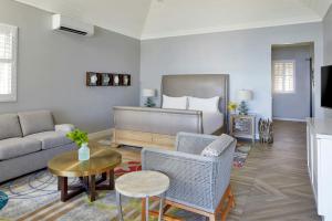 a living room with a bed and a couch and a table at French Leave Resort, Autograph Collection in Governorʼs Harbour