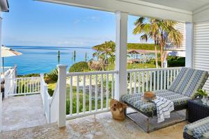 a porch with a chair and a view of the ocean at French Leave Resort, Autograph Collection in Governorʼs Harbour