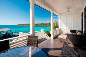 a screened in porch with a view of the ocean at French Leave Resort, Autograph Collection in Governorʼs Harbour