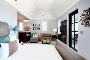 a bedroom with a bed and a living room at French Leave Resort, Autograph Collection in Governorʼs Harbour