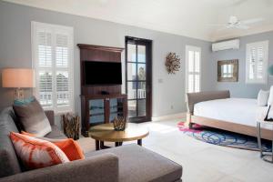 a living room with a bed and a tv at French Leave Resort, Autograph Collection in Governorʼs Harbour