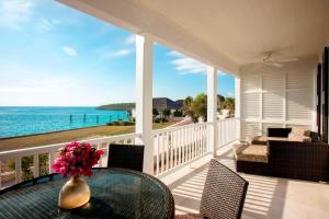 a porch with a vase of flowers on a table at French Leave Resort, Autograph Collection in Governorʼs Harbour