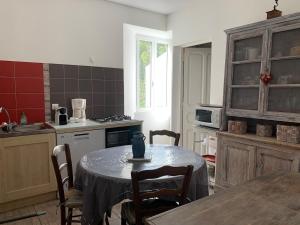 a kitchen with a table and chairs in a kitchen at Appartement Vezzani Centre Corse in Vezzani +5 photos