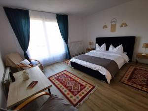a bedroom with a bed and a table and a window at Casa din Dâmb Mătișești in Mătişeşti