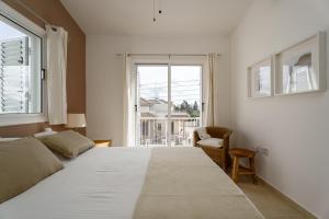 a bedroom with a large white bed and a window at Villa Poppy in Paralimni +52 photos
