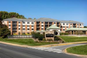 a large building with a sign in front of a street at Courtyard by Marriott Newark-University of Delaware in Newark