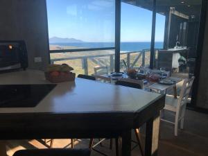 a dining room with a table and a view of the ocean at Olas de Pichicuy in Guaquen