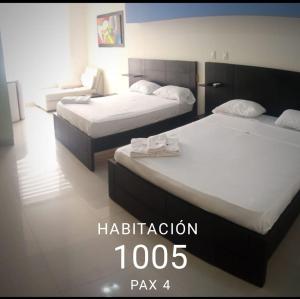 two beds in a hotel room with the wordsibliption at Playa Almendro Resort - Tonsupa in Tonsupa