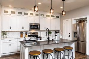 a kitchen with white cabinets and a counter with stools at Central Luxury Mountain Oasis with TWO Pools and Jacuzzis in Phoenix