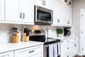 a kitchen with white cabinets and a stove top oven at Central Luxury Mountain Oasis with TWO Pools and Jacuzzis in Phoenix
