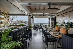 a restaurant with chairs and tables and windows at Academias Hotel, Autograph Collection in Athens