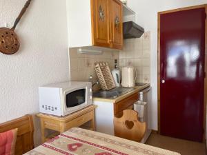 Una pequeña cocina con microondas y fregadero. en L'Alcove du Chinaillon, en Le Chinaillon 4 fotos más