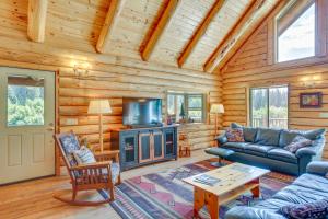 a living room with a couch and a fireplace in a log cabin at 13 Mi to Ski Slopes Log Home on 60 Private Acres! in McCloud