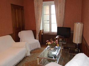 a living room with a couch and a table with a tv at Gîte de Louis - Vue imprenable - centre de Domme in Domme