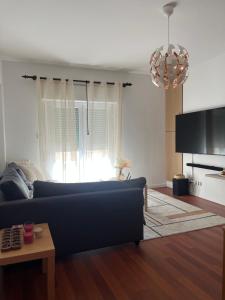 a living room with a blue couch and a tv at Apartment Santiago - Lisbon in Odivelas