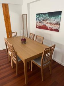 a wooden table with chairs and a vase on it at Apartment Santiago - Lisbon in Odivelas