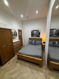 a bedroom with two beds and a mirror at Hendham House - Near Etihad Stadium, CoOp Live Arena, AO Arena, Piccadilly Train Station & Manchester City Centre in Manchester