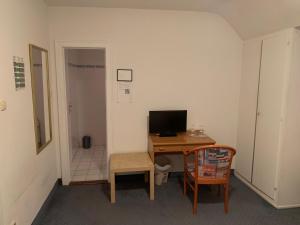 a room with a desk with a computer and a chair at Waldhotel Hensel's Felsenkeller in Frankfurt/Main