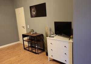 - une chambre avec une commode et une télévision en haut dans l'établissement Flensburg Süd, à Flensbourg 10 autres photos