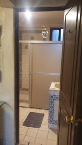 baño con ducha, lavabo y puerta en Torreón 2 - Habitación cerca del aeropuerto con alberca, en Torreón
