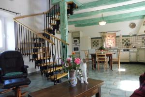 a living room with a staircase and a table with flowers at Gîte Le Bédigas in Béduer