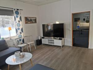 a living room with a couch and a flat screen tv at Guldklimpens Vandrarhem in Gunnarn