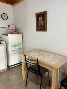 Una cocina con una mesa de madera y un refrigerador. en Hospedaje Río, en Río Primero
