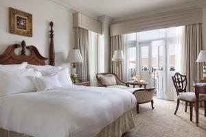 a bedroom with a large white bed and a desk at Market Pavilion Hotel in Charleston