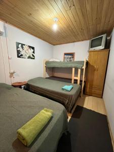 Una pequeña habitación con dos camas y un televisor. en Hospedaje Río, en Río Primero