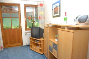 a room with a tv and a desk with a phone at Oberbauernhof - Wohnung "Stübleberg" -- Moderne FeWo im schönen Schwarzwaldhaus in Gutach