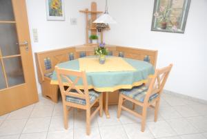 a dining room table with chairs and a vase of flowers on it at Oberbauernhof - Wohnung "Stübleberg" -- Moderne FeWo im schönen Schwarzwaldhaus in Gutach