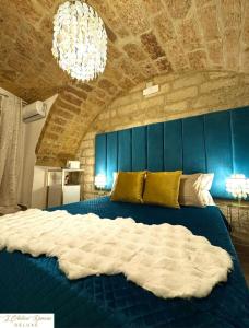 una camera da letto con un grande letto blu e un lampadario a braccio di L'Antica Dimora Deluxe a Bari