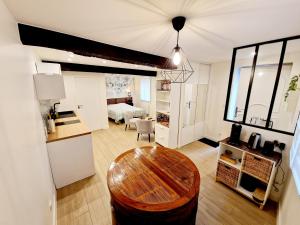 a living room with a table and a kitchen at Studio fonctionnel avec Wi-Fi idéal séjour Pro ou à deux in Cailloux-sur-Fontaines