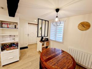 a living room with a wooden table and a window at Studio fonctionnel avec Wi-Fi idéal séjour Pro ou à deux in Cailloux-sur-Fontaines