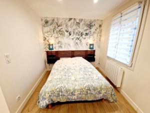 a bedroom with a bed with a floral bedspread at Studio cosy Proche Lyon Arrivée autonome in Cailloux-sur-Fontaines