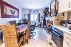 a kitchen and dining room with a wooden table and chairs at Villa Les Mimosas - 3 chambres d'hôtes in Plassac