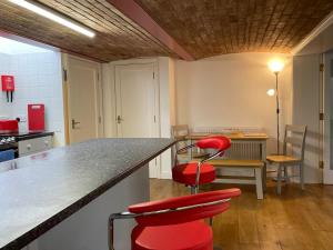 HenwickにあるPrivate city apartment, Upper Tything, Worcester City Centreのキッチン(カウンターと赤いスツール2脚付)