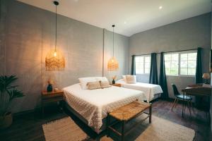 a bedroom with two beds and a desk and a piano at El Xalli Hotel in El Zonte +166 photos