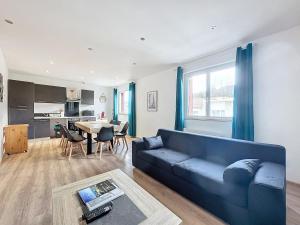 a living room with a blue couch and a table at Apartment 10pers Aubière , Parking, WiFi - TV in Aubière