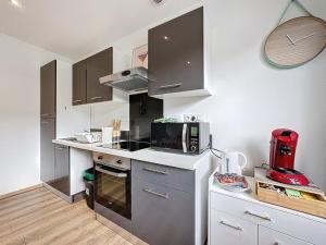 a kitchen with a microwave and a stove top oven at Apartment 10pers Aubière , Parking, WiFi - TV in Aubière +6 photos