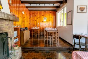 a dining room with wooden walls and tables and chairs at VELINN Pousada Casa de Campos Capivari House in Campos do Jordão