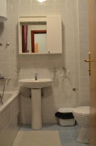 a bathroom with a sink and a toilet and a mirror at Hotel Dva Javora in Jahorina